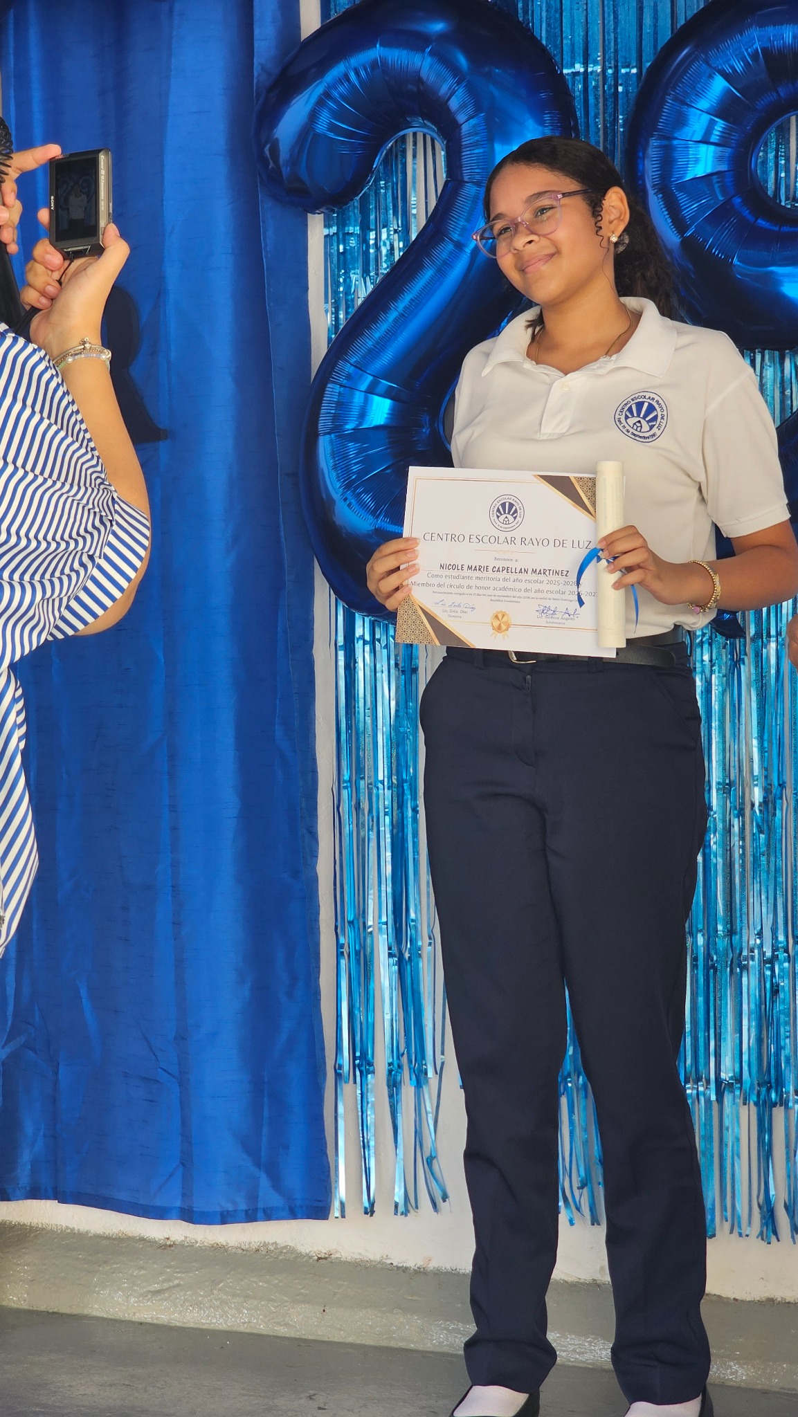 Nicole Marie Capellán Martínez muestra su reconocimiento académico de CERLUZ